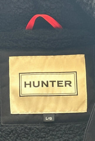 Close-up of a Hunter jacket with a gold label on a dark background