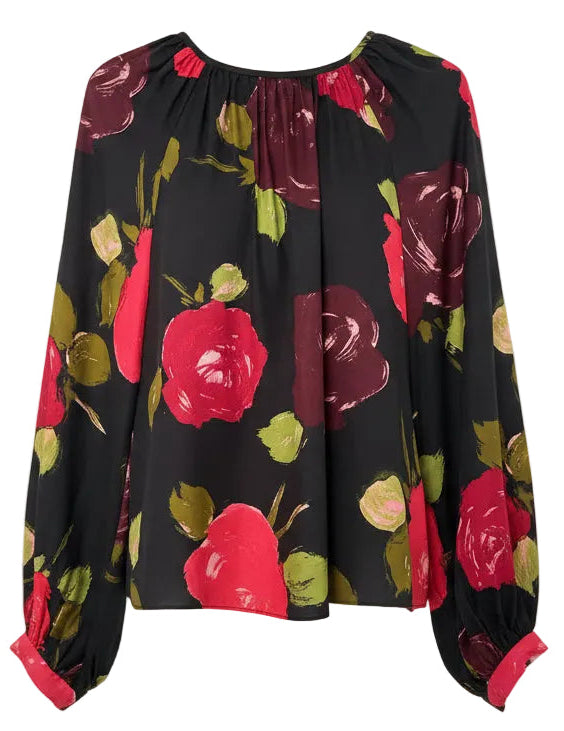 Black blouse with red and green floral pattern on a hanger against a white background
