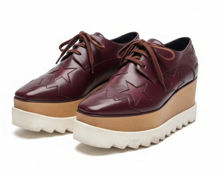 Brown leather shoes with star design and platform sole on a white background