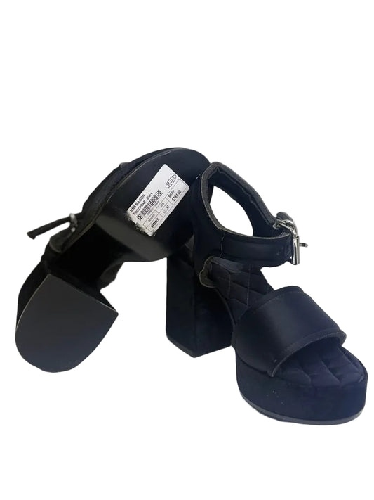Black sandals with a brand label on a white background