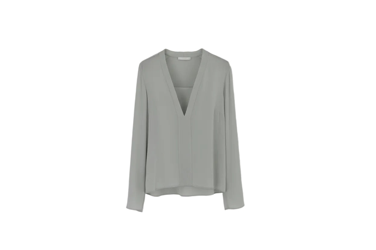Light gray blouse on a hanger against a white background