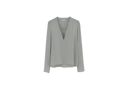Light gray blouse on a hanger against a white background