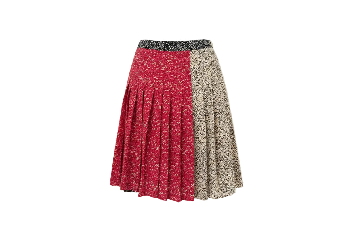 Two patterned skirts hanging on a wooden hanger against a white wall.