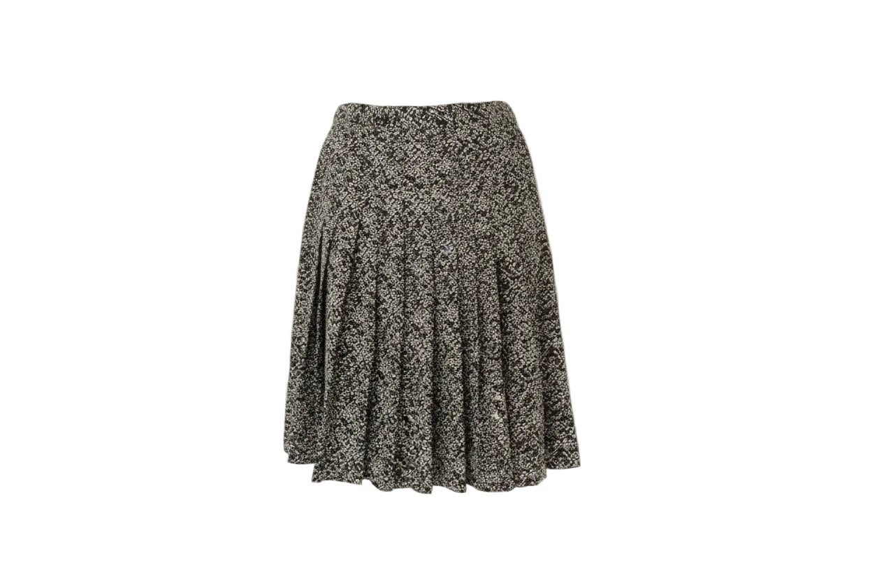 Floral patterned skirt on a wooden hanger against a white wall