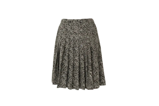 Floral patterned skirt on a wooden hanger against a white wall