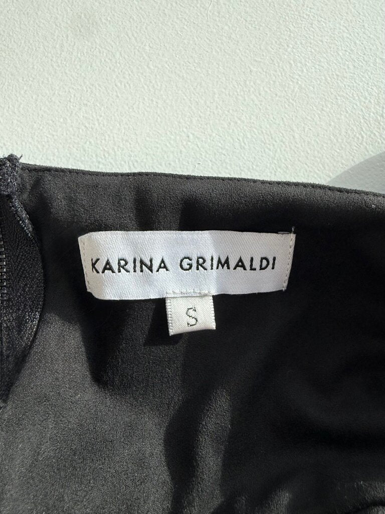 Karina Grimaldi label on a black garment with a white background